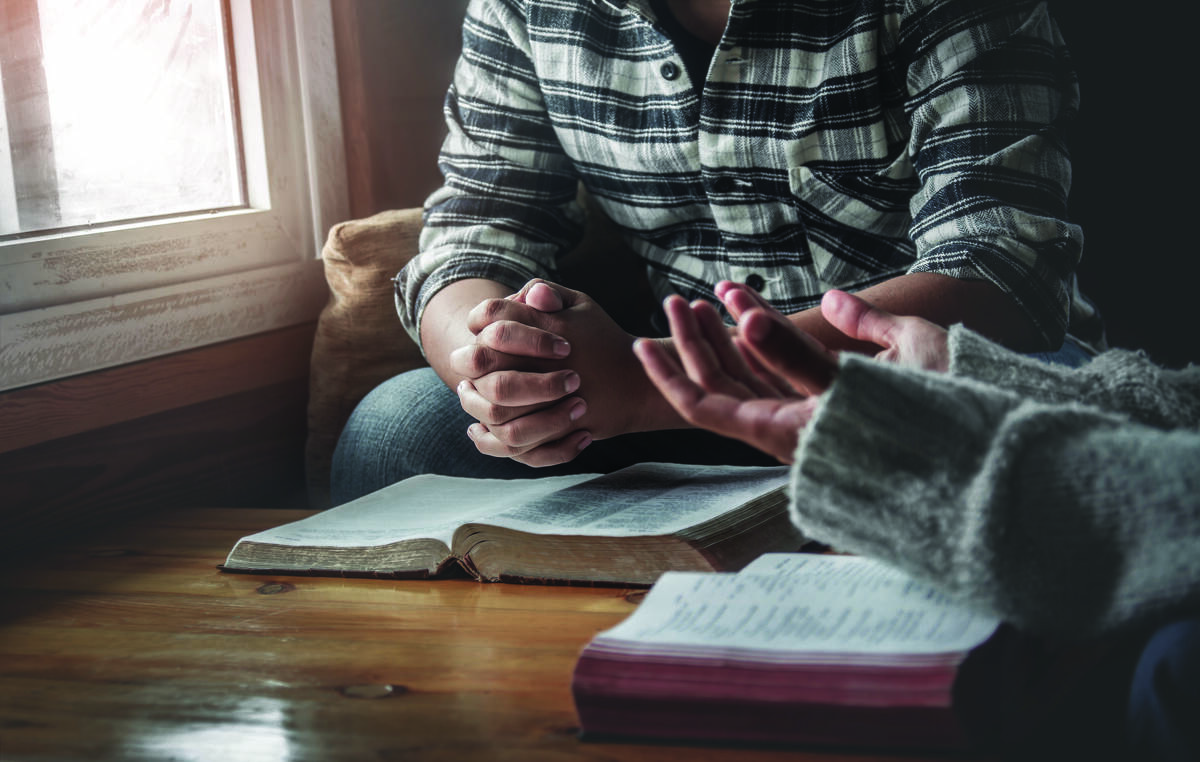 people praying around a table