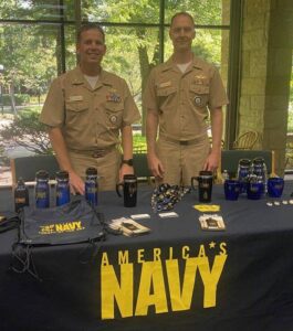 Navy Chaplains Rick Williams and Jared Smith standing at their booth in the library. width=