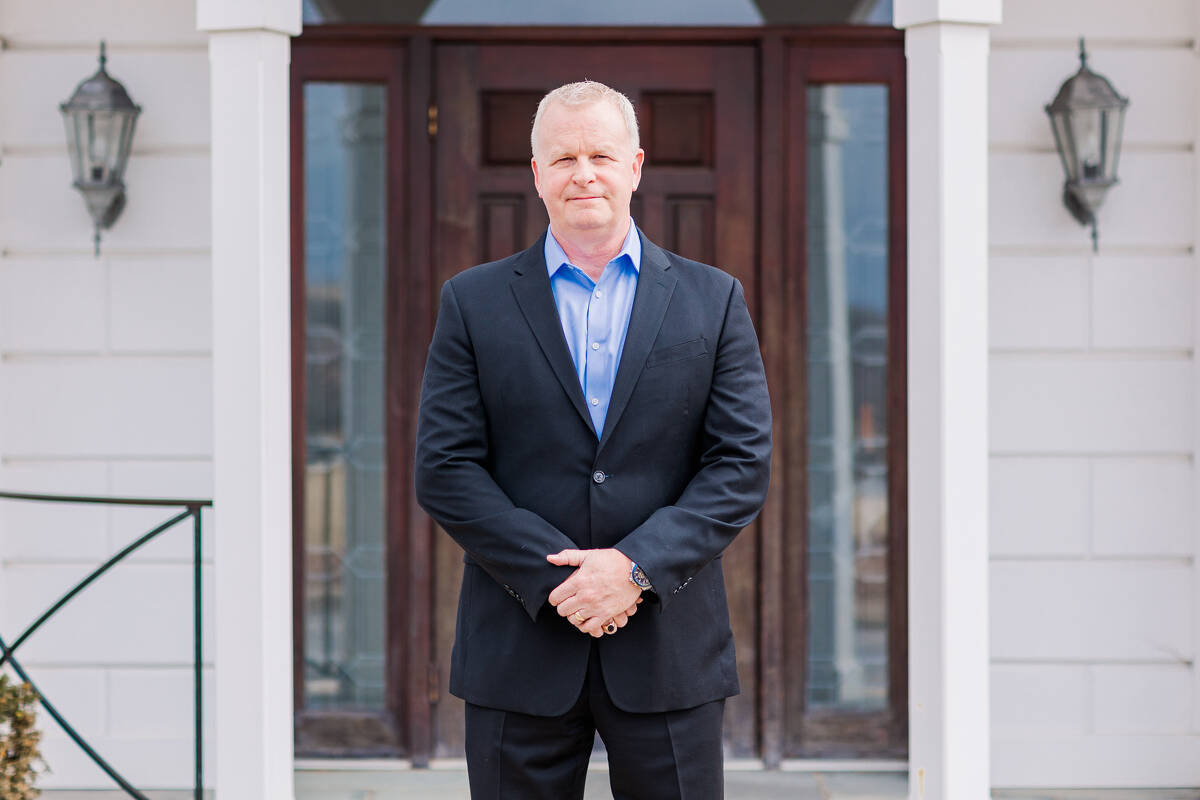 David Magnuson standing infront of the mansion door on campus