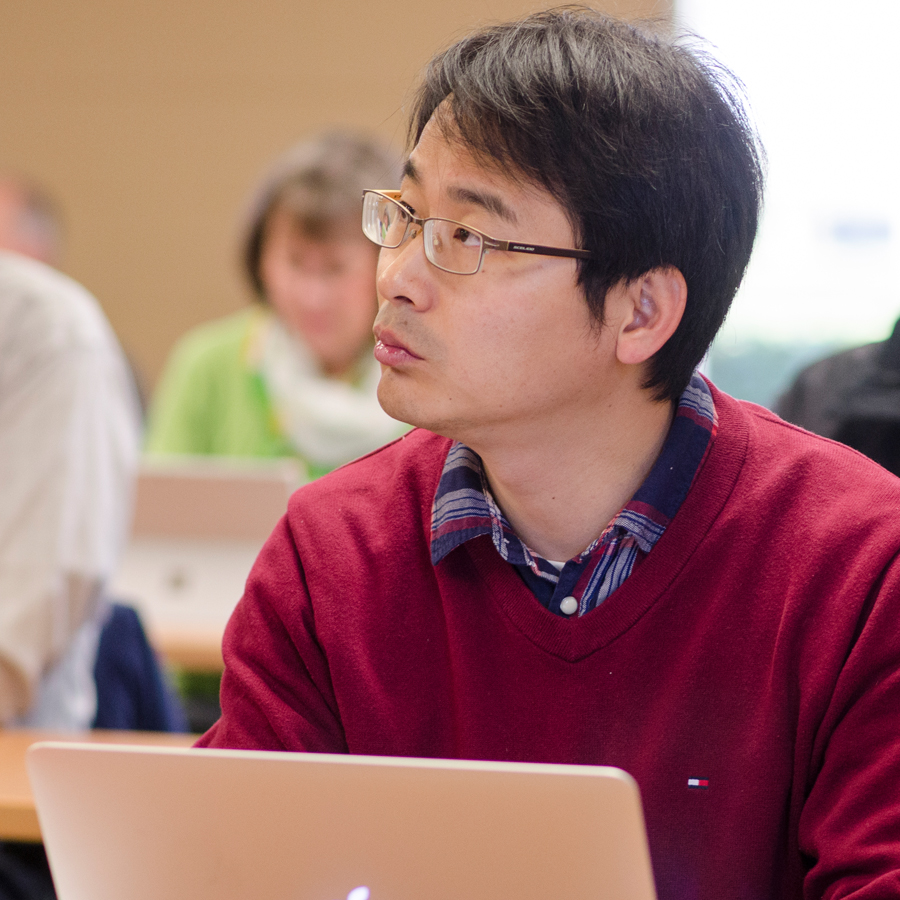 Man looks up while studying in a class