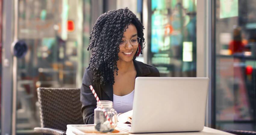Student using computer outside a cafe